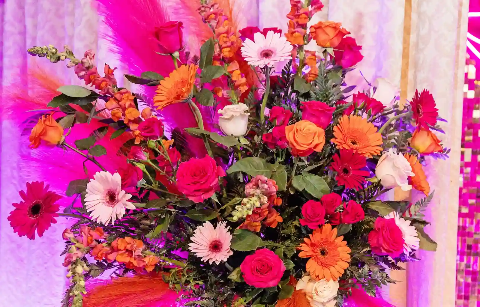 Disco-themed wedding altar floral spray with pink and orange roses and gerbera daisies at Viva Las Vegas Weddings chapel