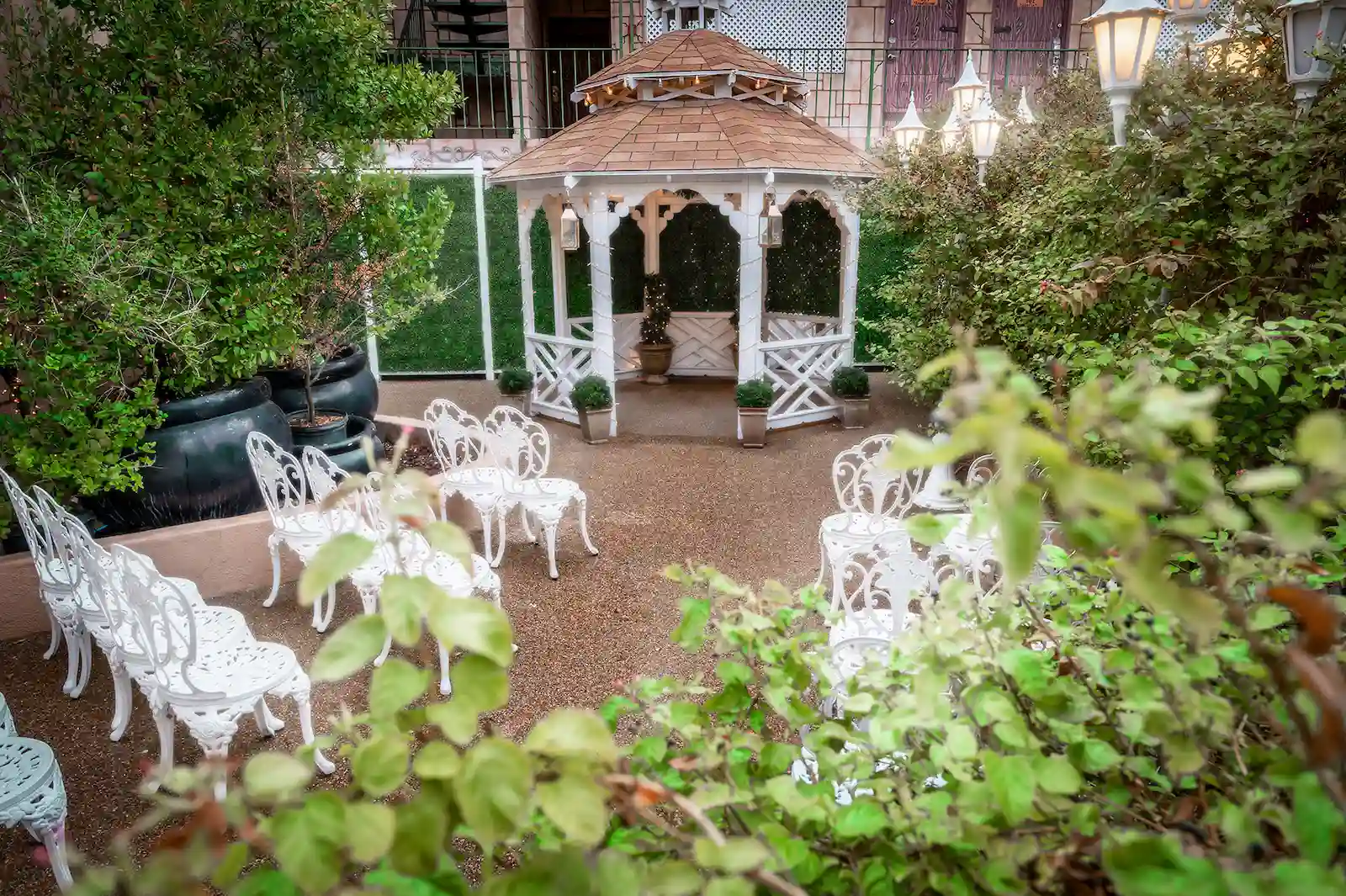Boulevard Gazebo outdoor garden wedding ceremony venue with white iron chairs and lush greenery at Viva Las Vegas