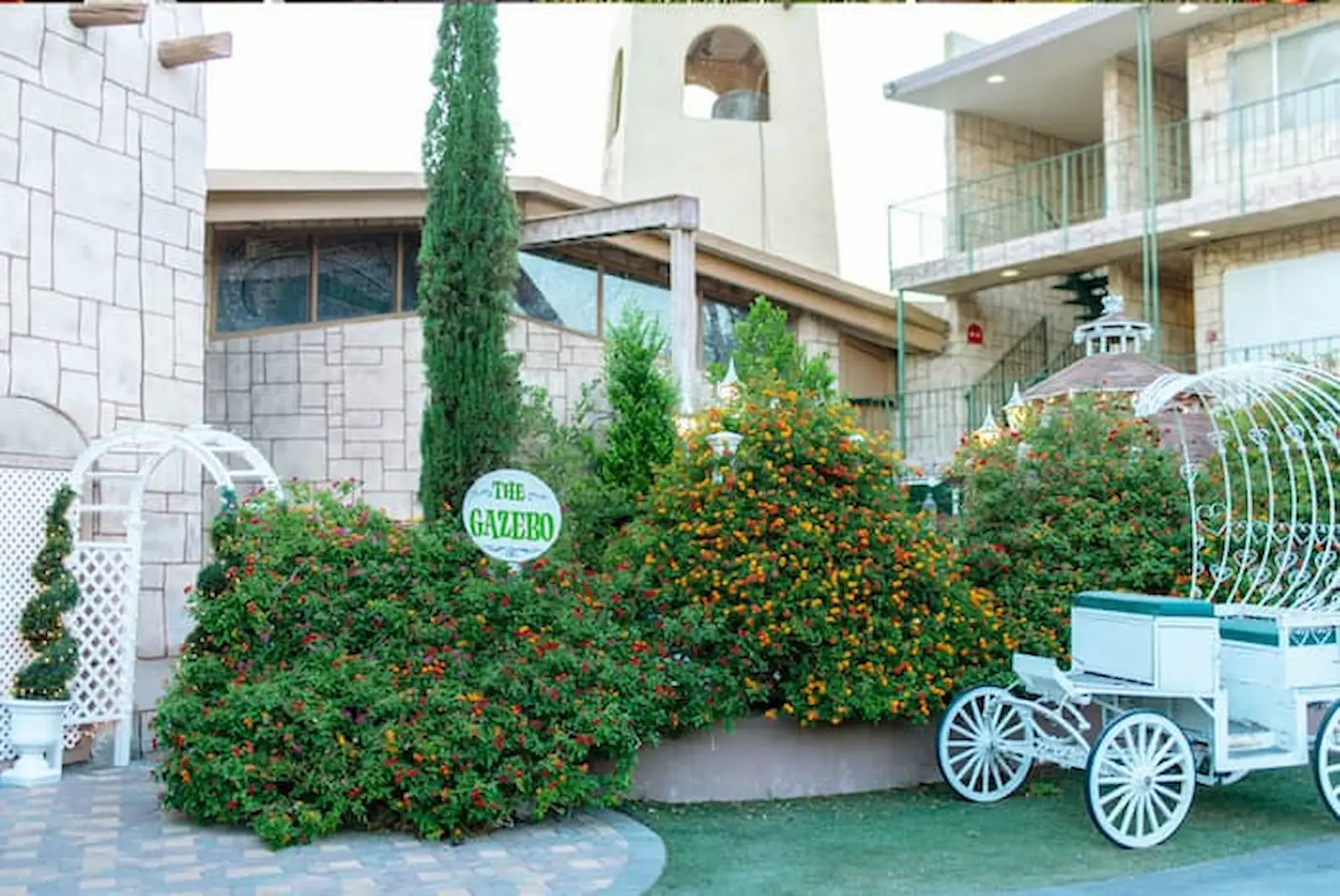 The Gazebo outdoor wedding venue entrance with Cinderella carriage and flowering garden at Viva Las Vegas