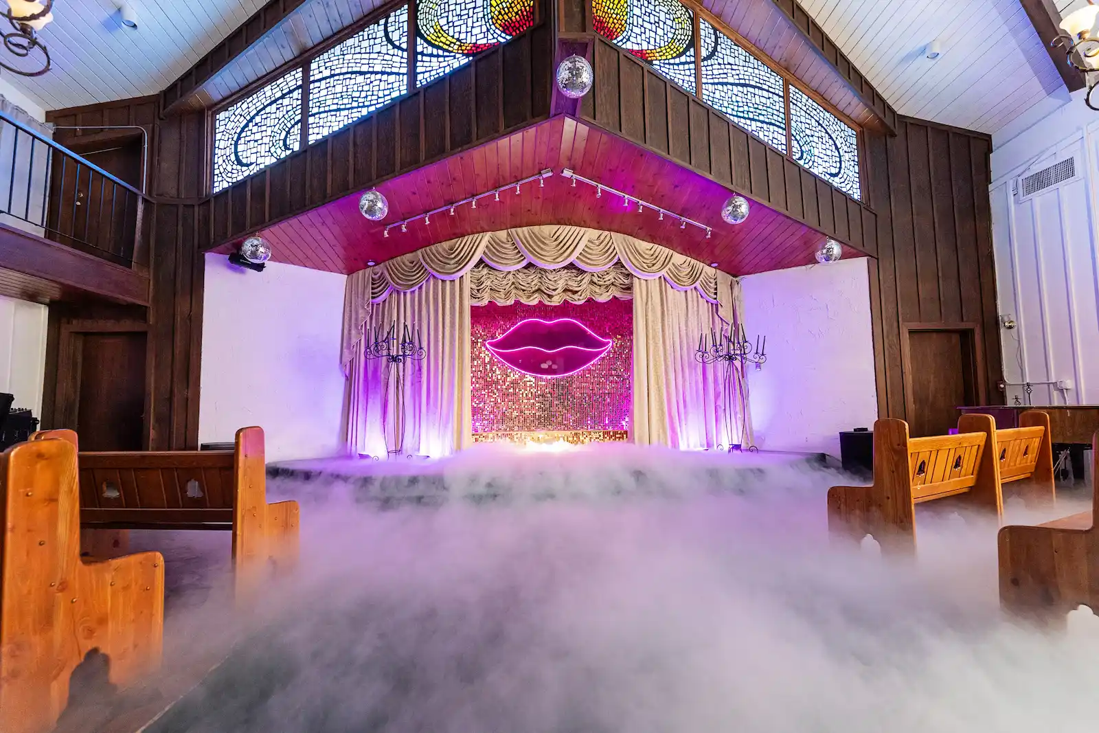 Vegas wedding chapel aisle with neon lips sign, sequin backdrop, and dramatic fog effect