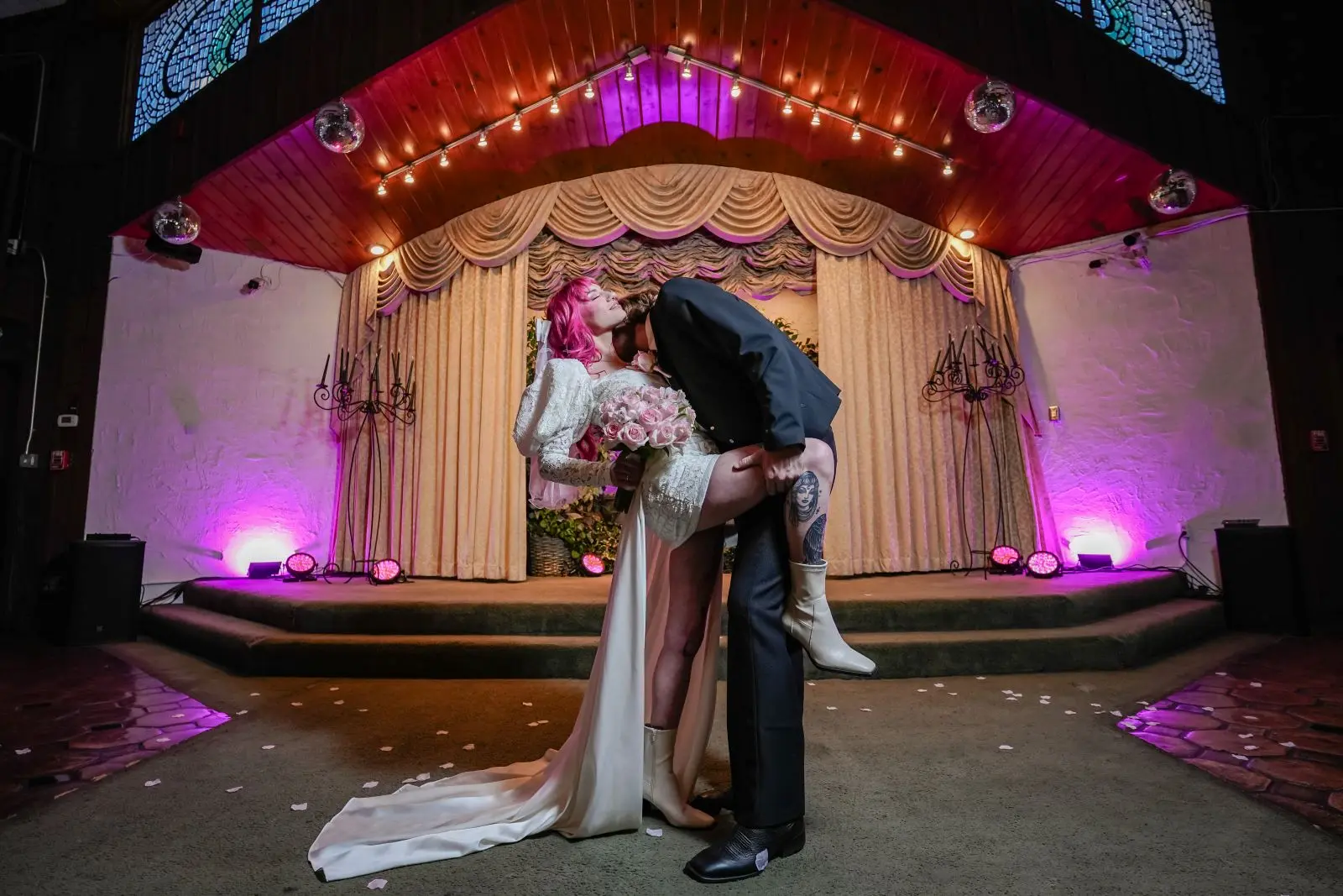 Bride with pink hair and groom sharing first kiss dip at Viva Las Vegas Wedding Chapel